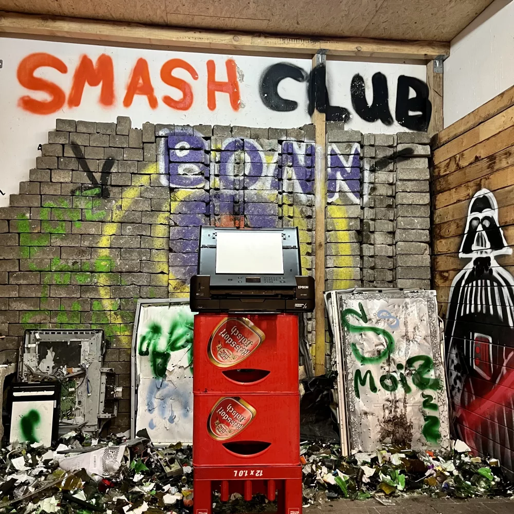Drucker auf Bierkästen und Logo im Hintergrund im Classic-Smash Raum